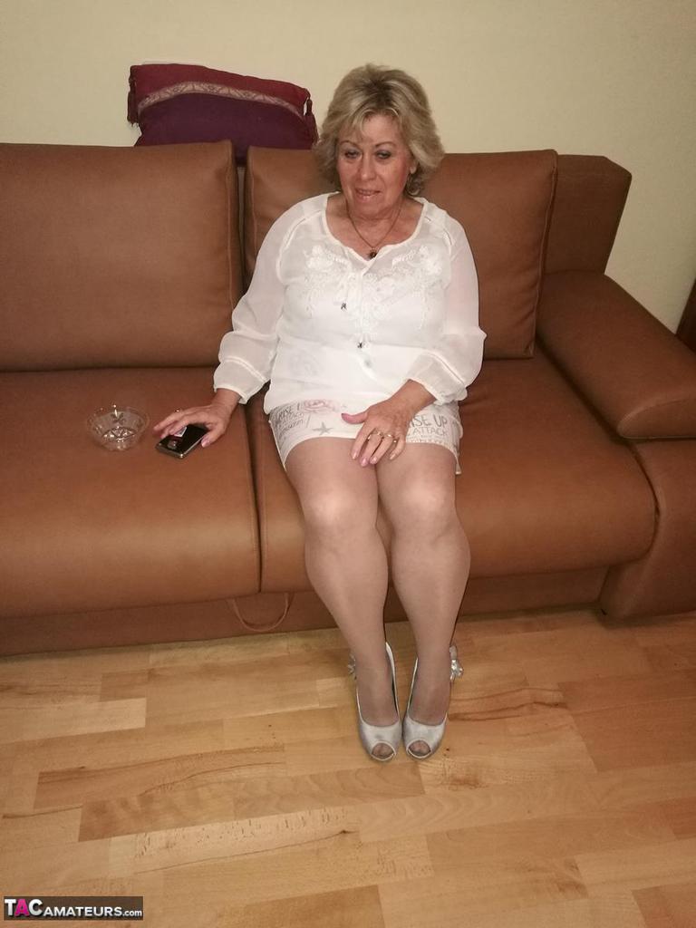 Mature lady exposes her large tits while having a smoke in pantyhose(1)