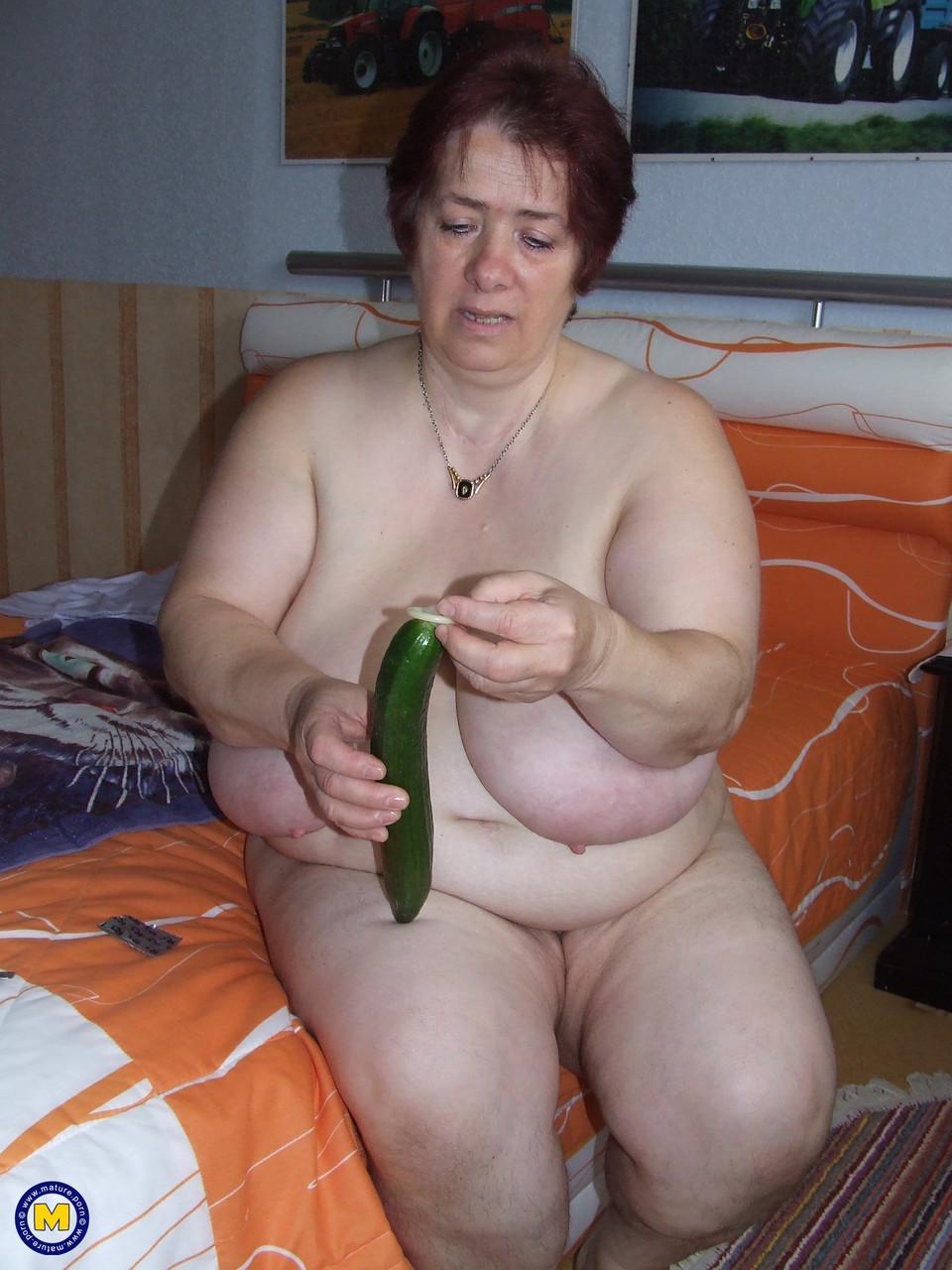 Fat mature Corinna puts a condom on a huge cucumber and masturbates(3)