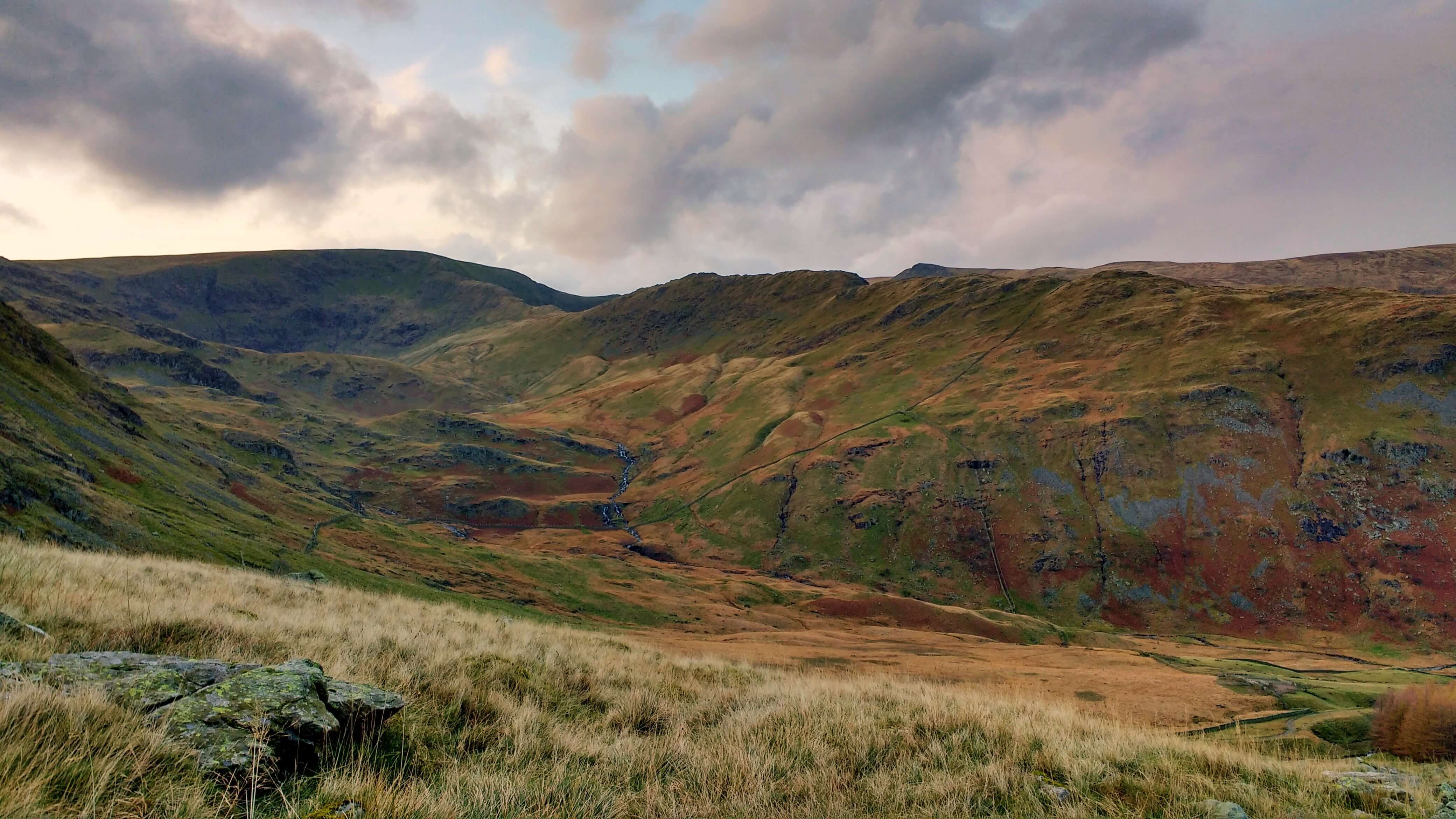 A valley with pink clouds above