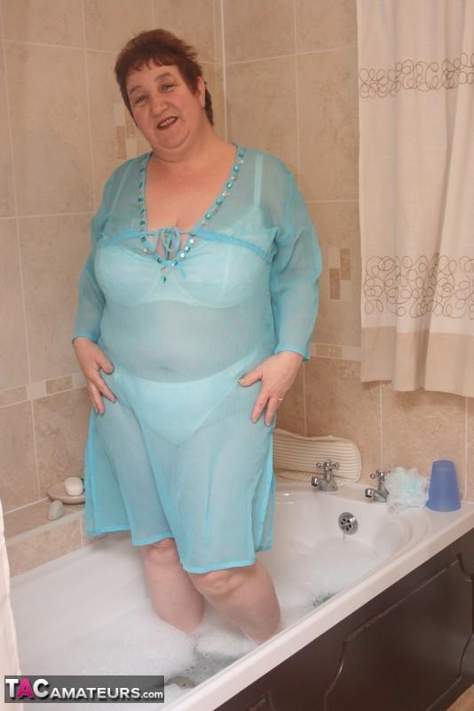 Redhead nan Kinky Carol parks her fat figure in a tub while fully clothed(10)