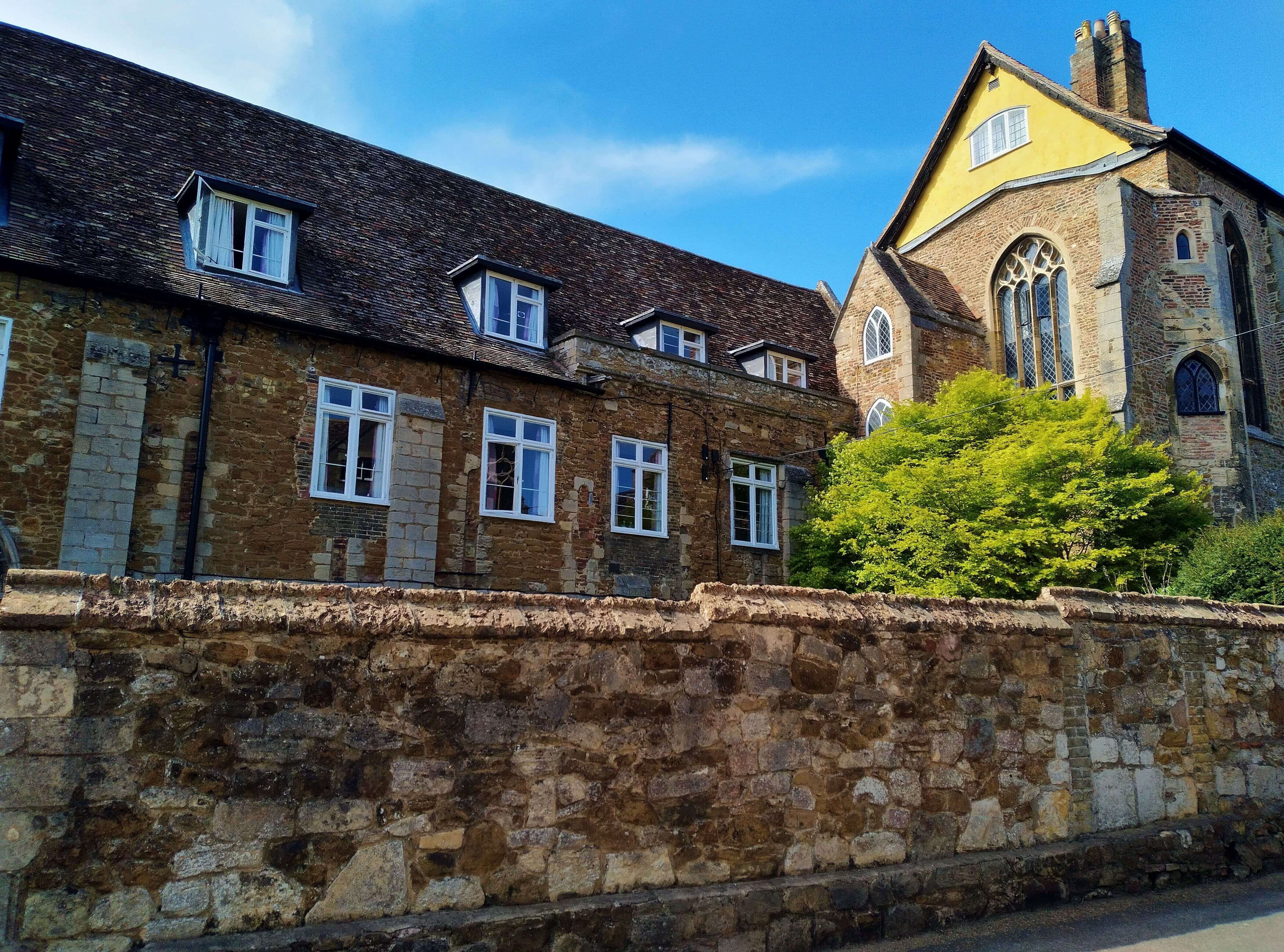 A row of old houses behind a brick wall