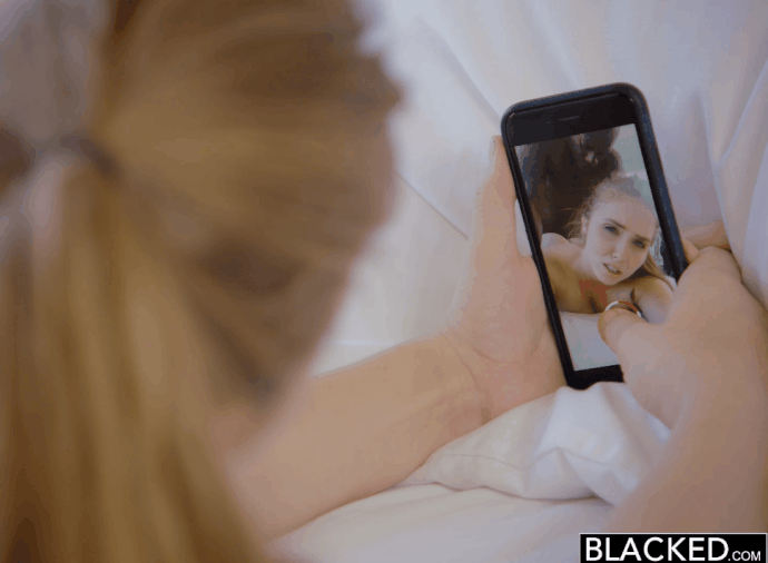 Busty white woman records herself having sex with bald black man on bed
