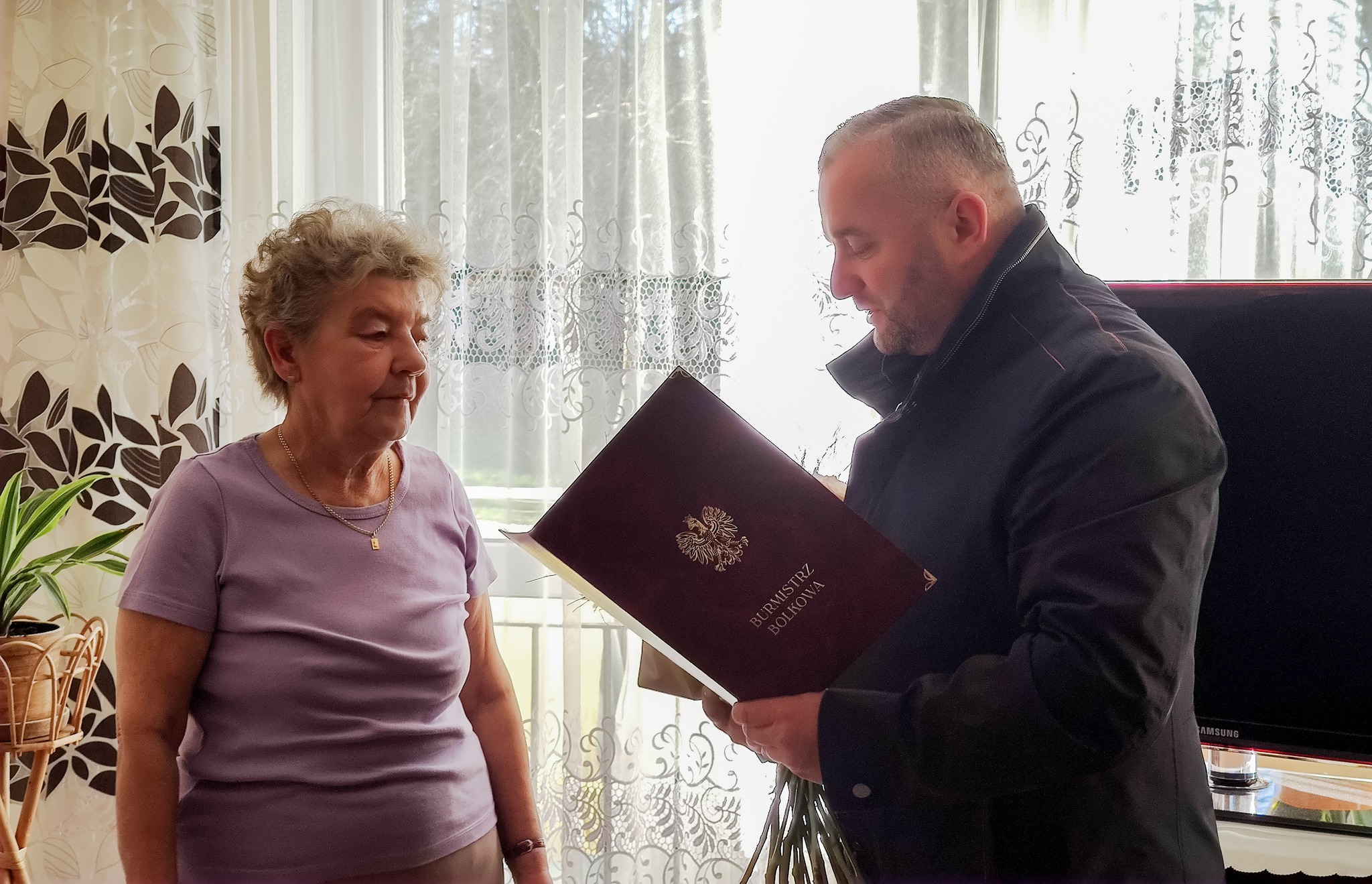 na zdjęciu Burmistrz Bolkowa Grzegorz Kucab wręczający życzenia dla 100 latki