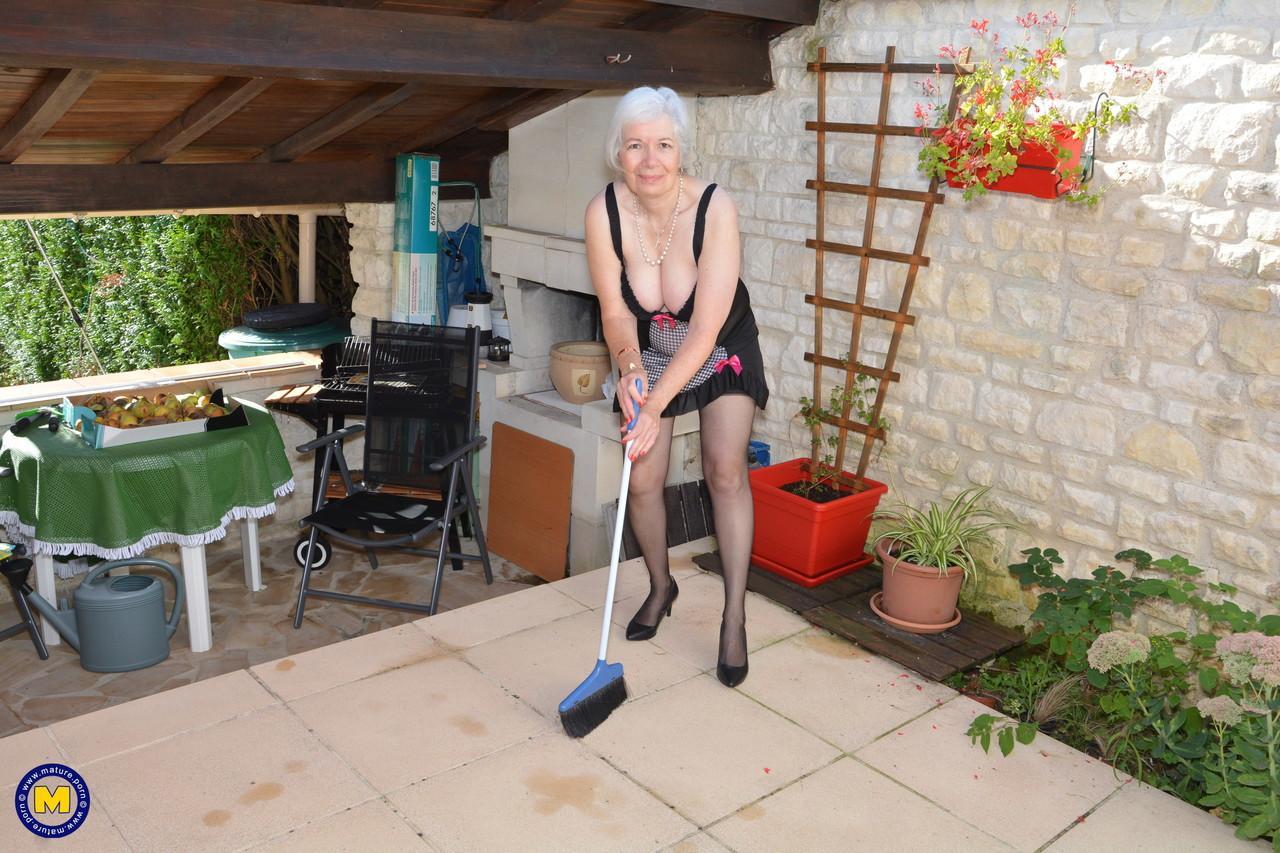 Horny granny lifts her sexy skirt to play with her beaver in the garden(1)