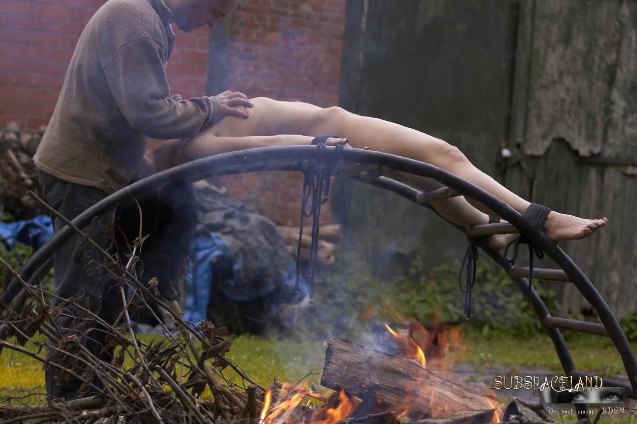 Naked brunette Ally Style is roasted over a fire during BDSM training(12)