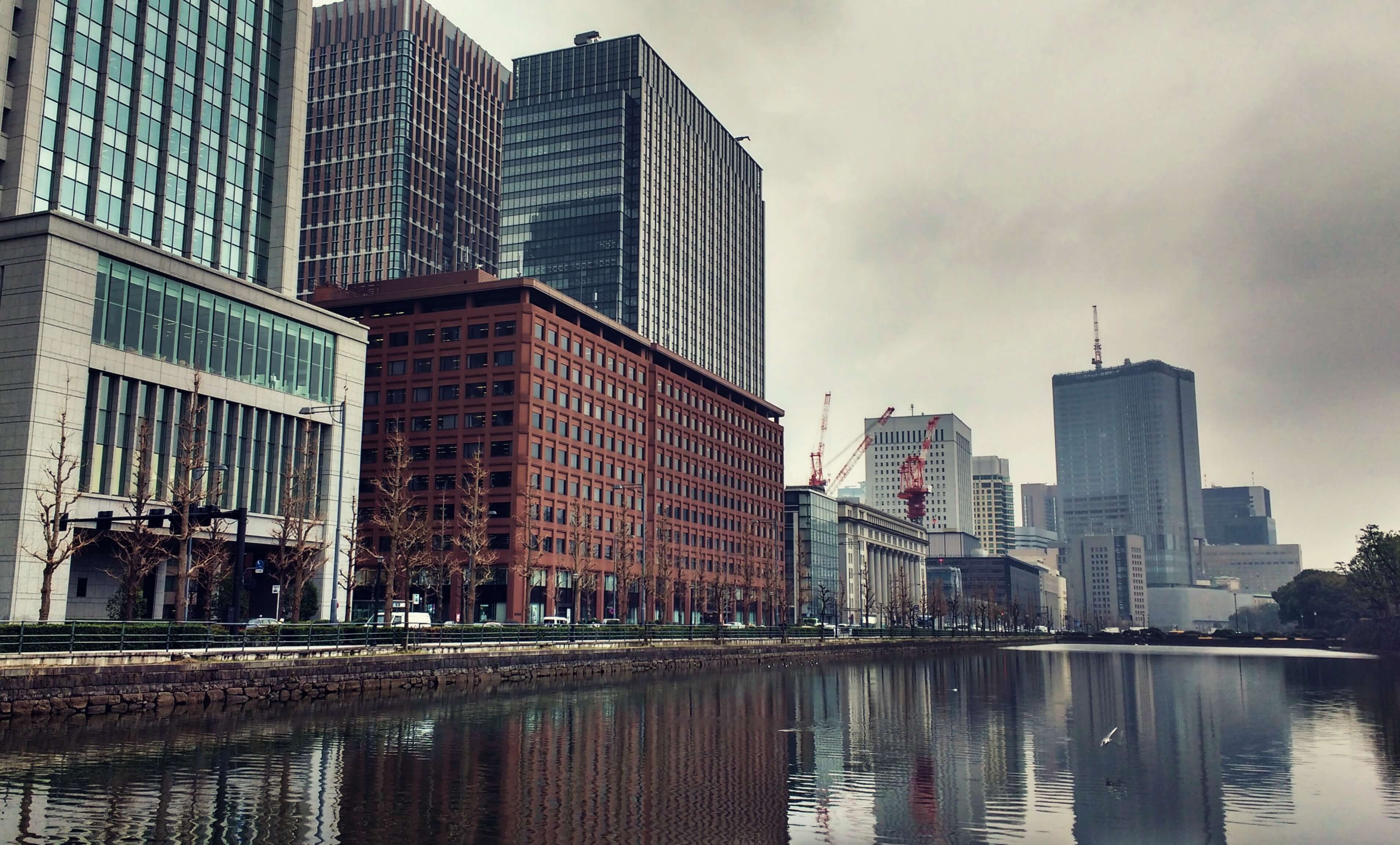 Tall grey buildings standing behind a river