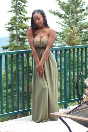 Ebony amateur Amber releases her big tits from a long dress on a balcony