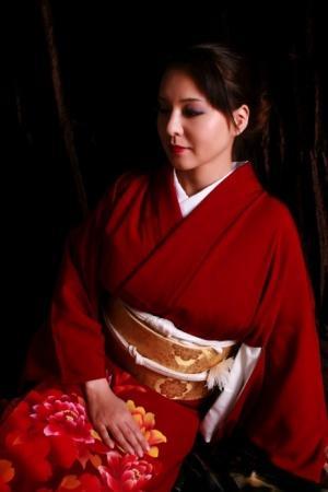 Japanese woman sports red lips while producing a knife in traditional clothing