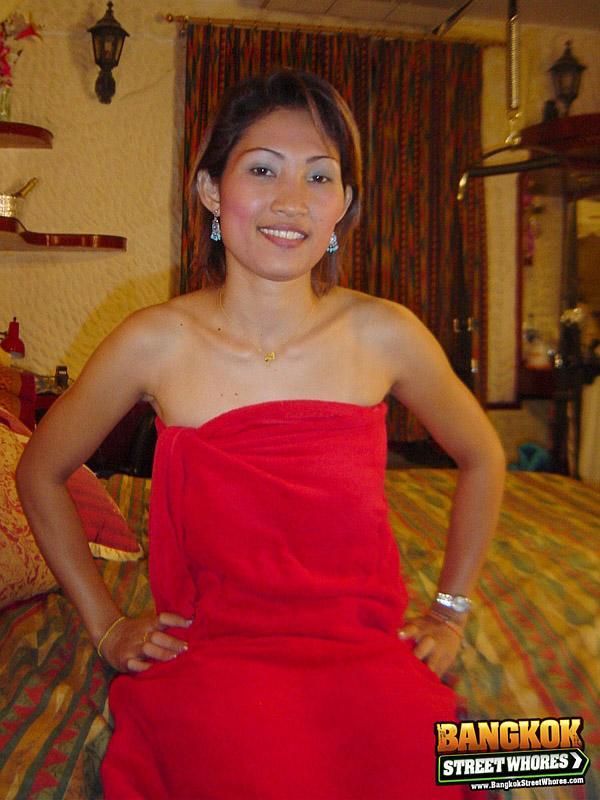 Slender Thai girl uncovers her natural tits as she removes red dress on bed(2)