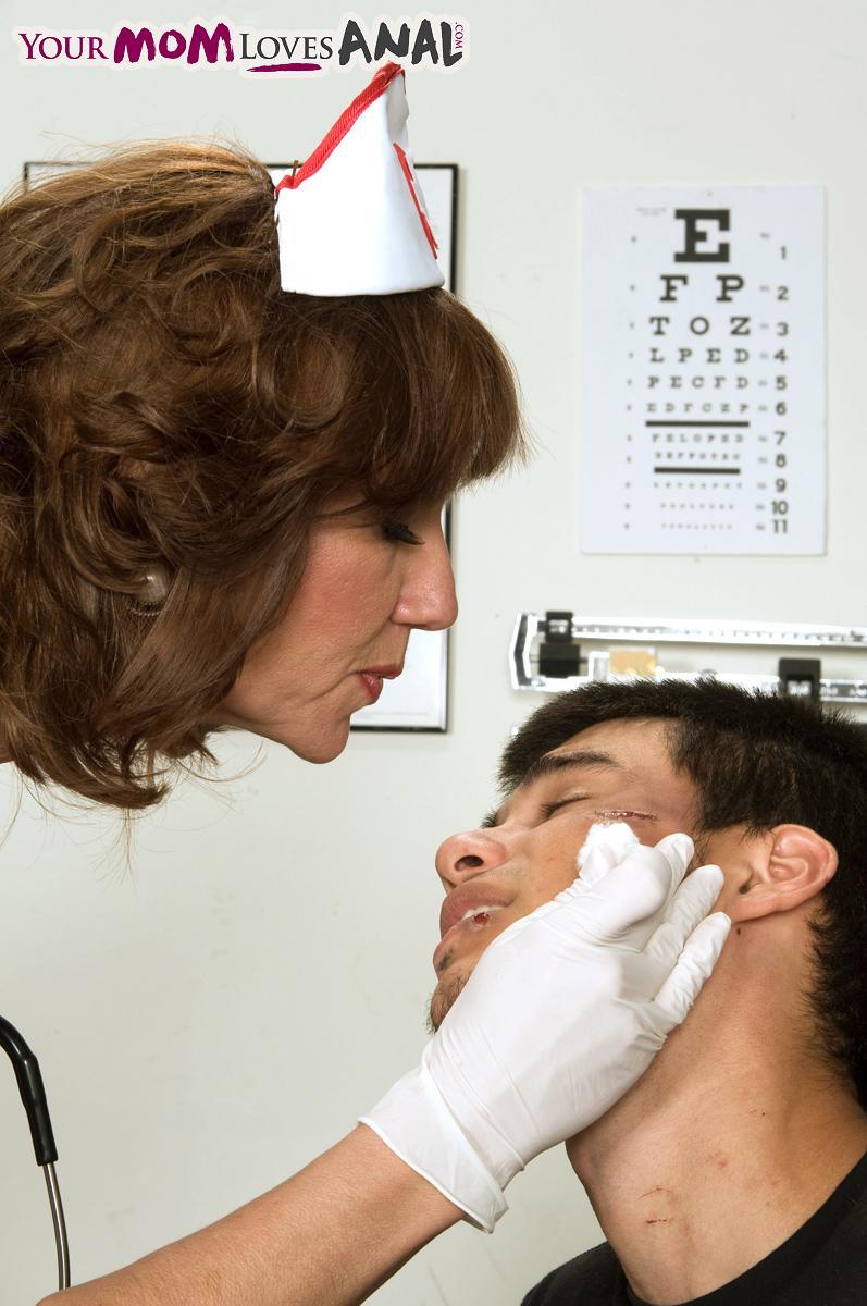 Mature nurse Elle Denay swaps oral with a young boy after cleaning his wounds(2)