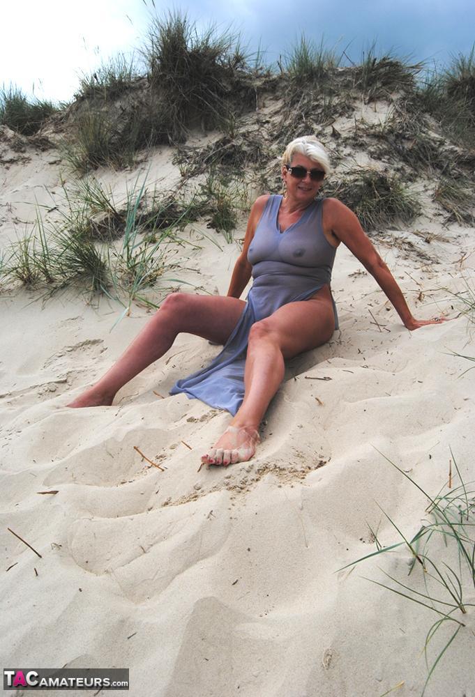 Beautiful busty mature Dimonty poses fully clothed in sheer dress at the beach(6)