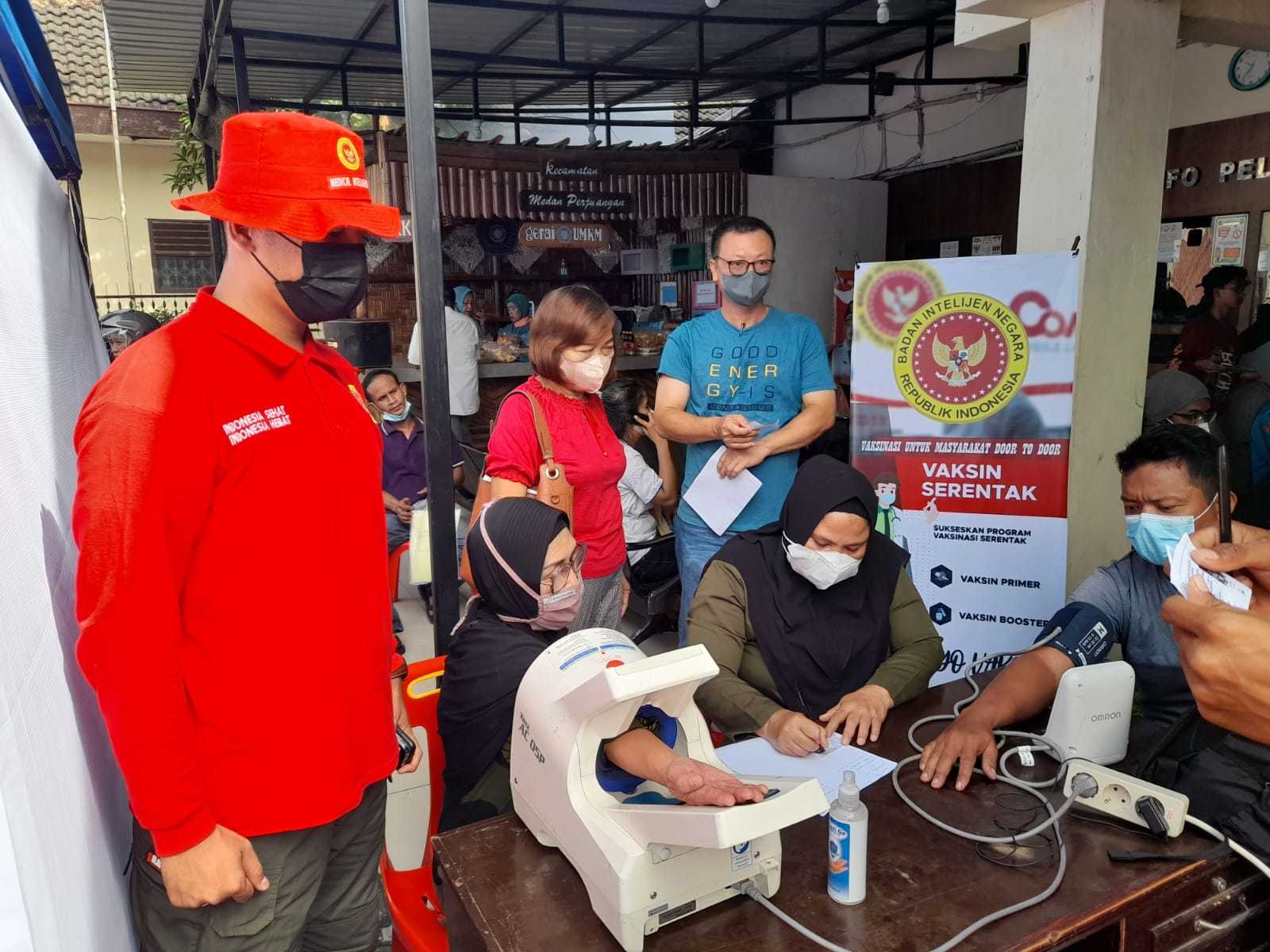 Personil Binda Sumut dan Camat Medan Perjuangan Zul Ahyudi Solin, Ap. MSi menyampaikan bantuan Minyak goreng pada peserta vaksinasi bagi 1500 masyarakat di kantor Camat Medan Perjuangan, Rabu (22/6/2022)