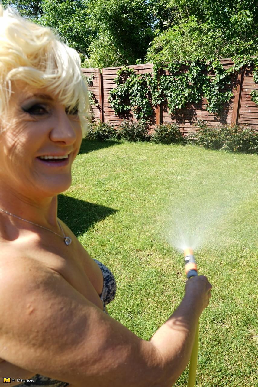 Mature blonde woman takes off her bikini while wandering around her property(6)