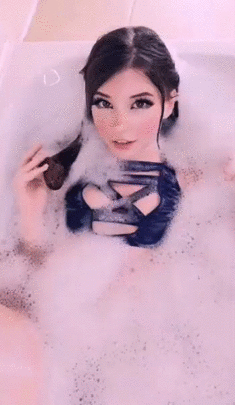 Brunette in bath plays with hair