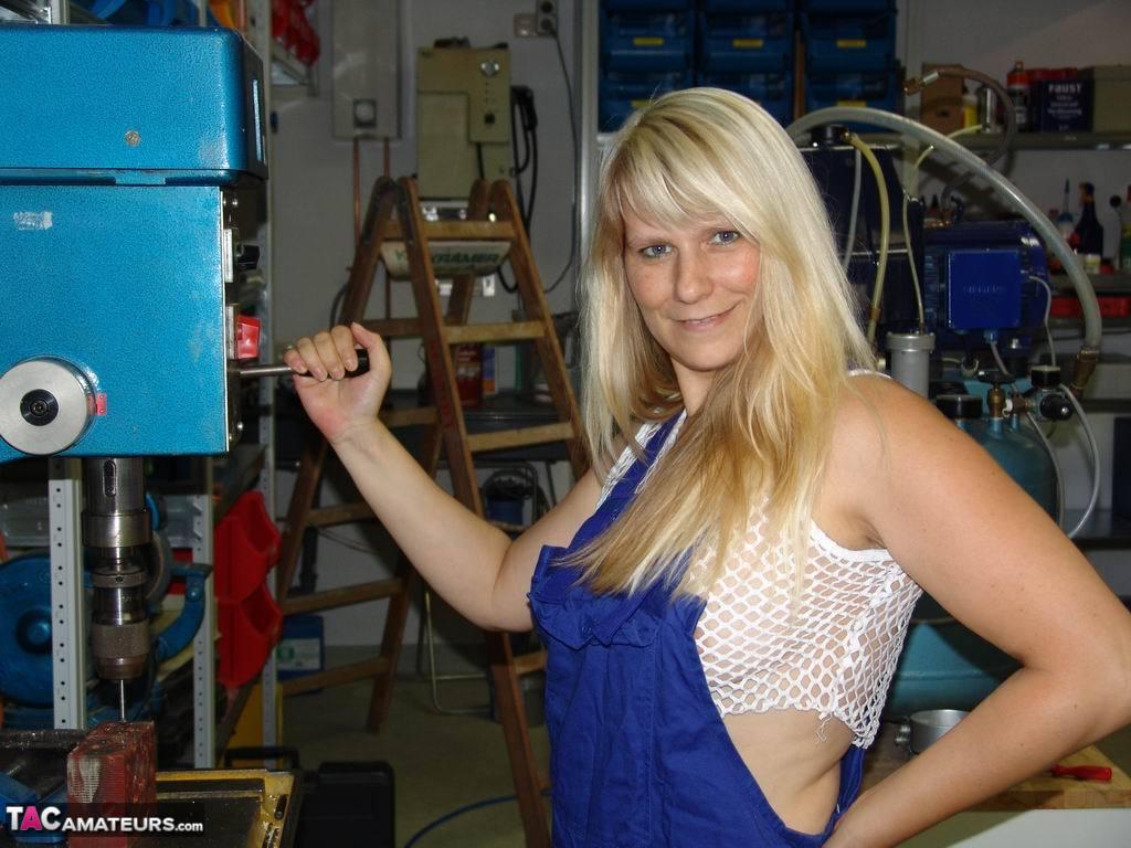 Mature blonde removes her overall before masturbating in workshop(2)