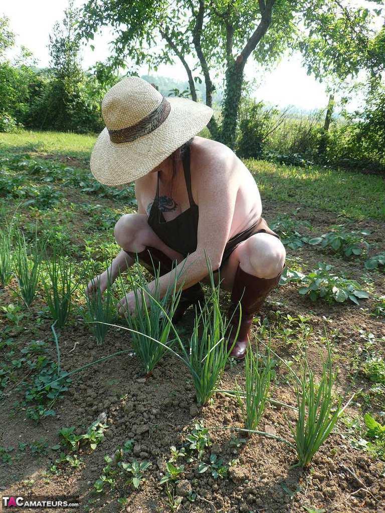 Mature lady Mary Bitch tends to her garden while naked in sunhat and apron(5)